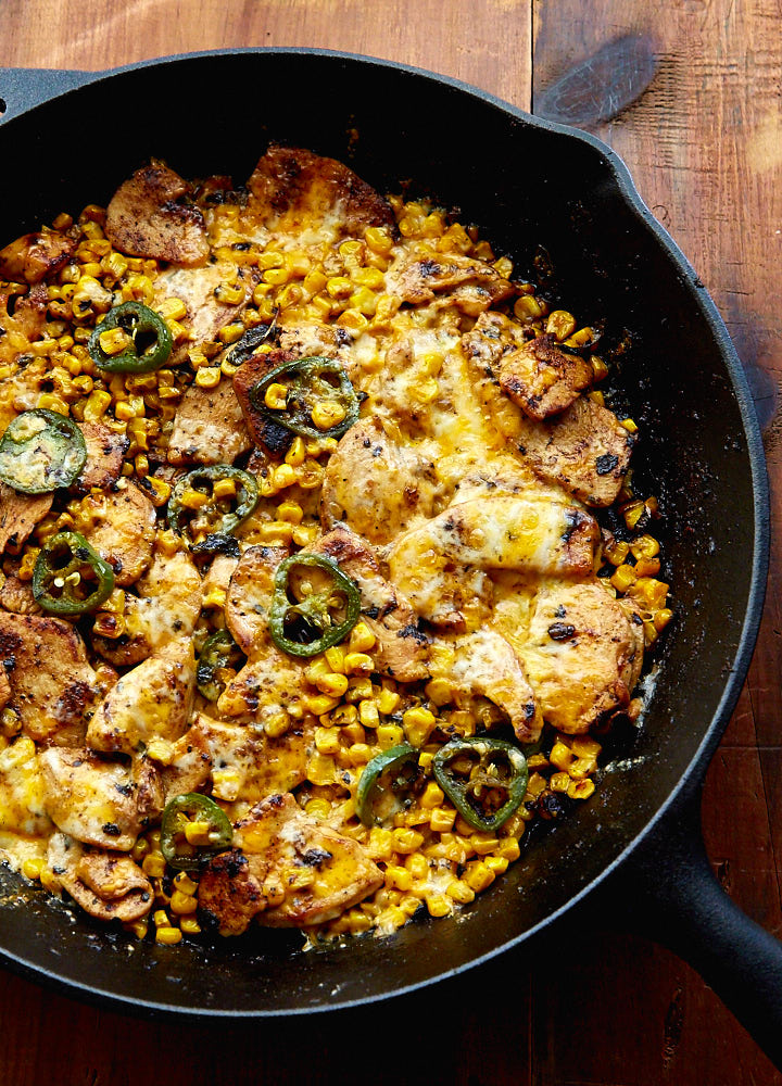 Mexican Chicken with Corn, Chilies and Cheese in a cast iron pan.