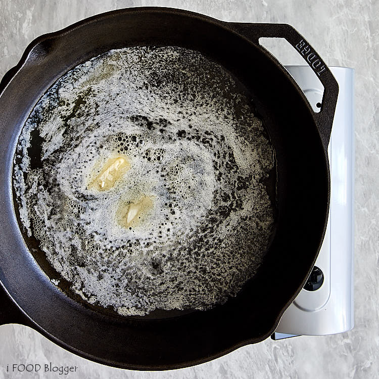 Melting butter in a black cast iron pan.
