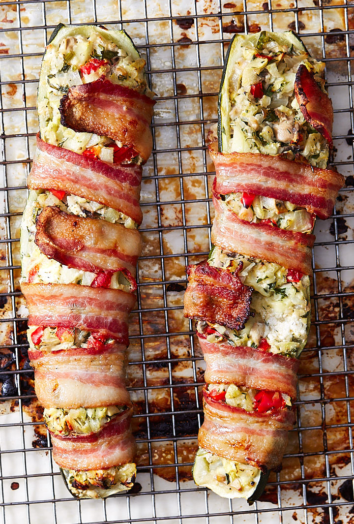 Stuffed zucchini boats on a baking sheet fitted with a cooling rack.