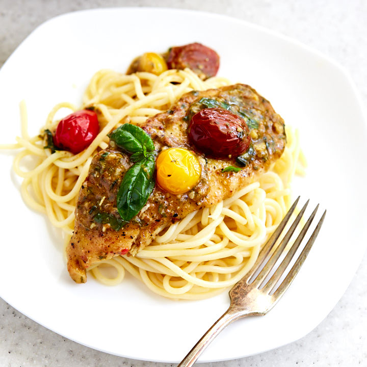 Pesto chicken on a bed of pasta.