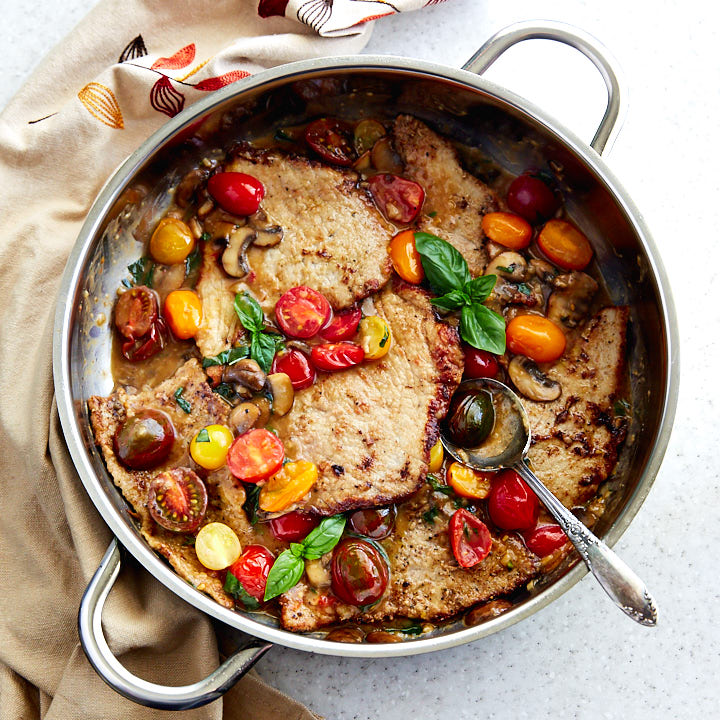 Veal scallopini in a saute pan.