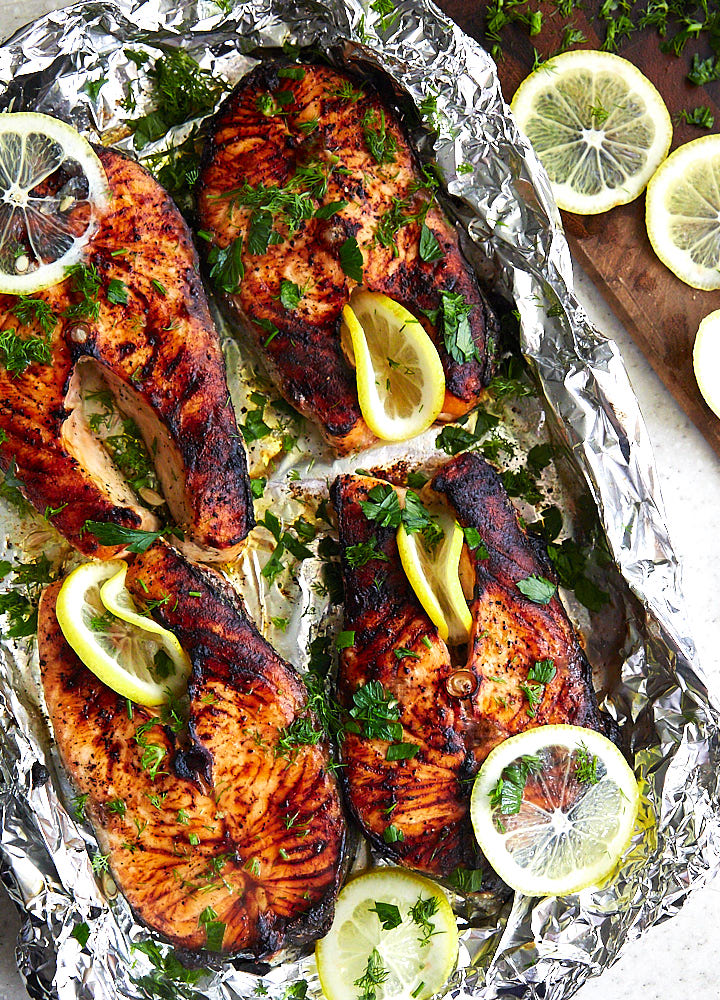 Broiled salmon steaks on foil.