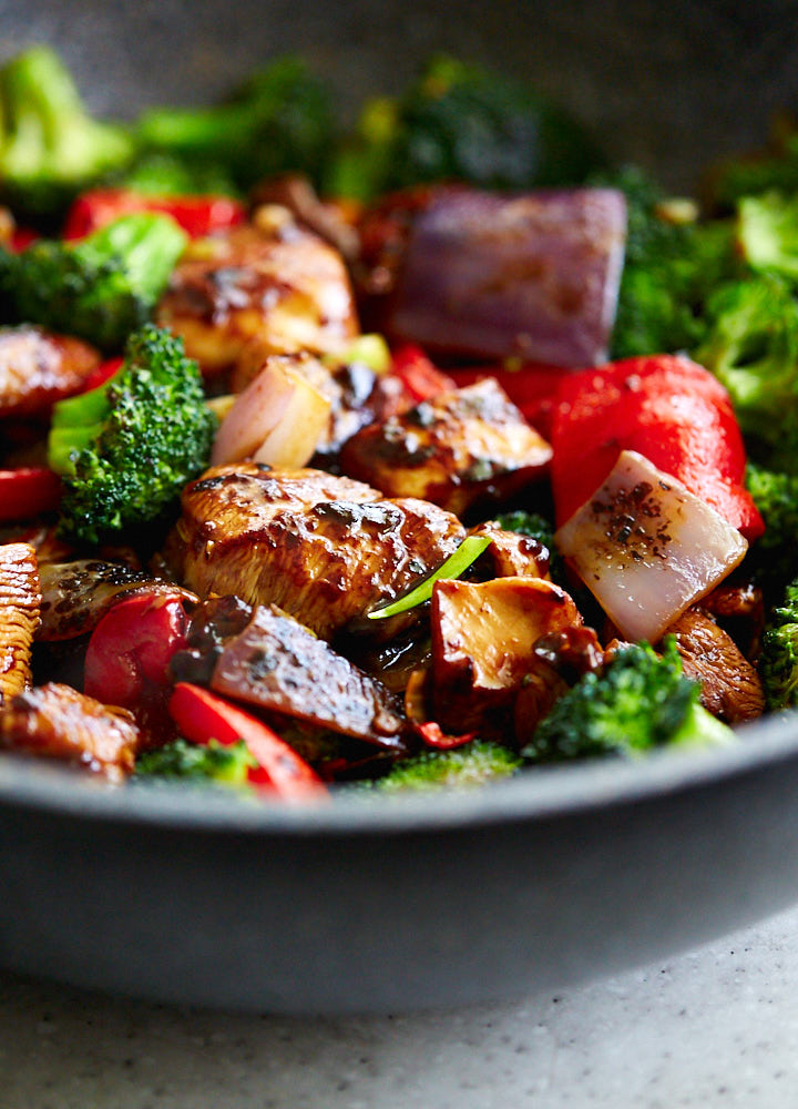 Side view of Hunan chicken in a large wok.