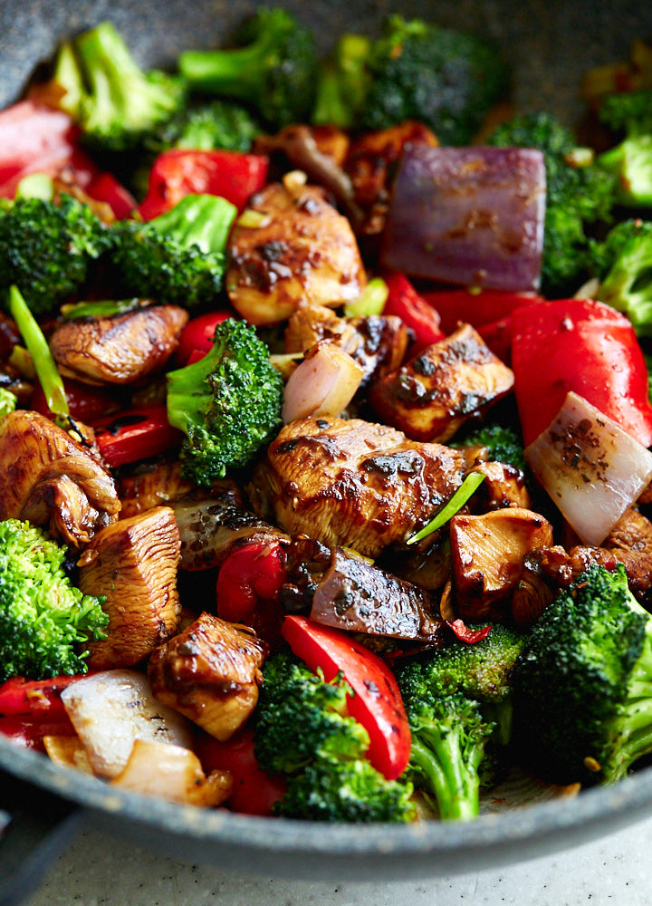 Hunan chicken with vegetables in a large wok.