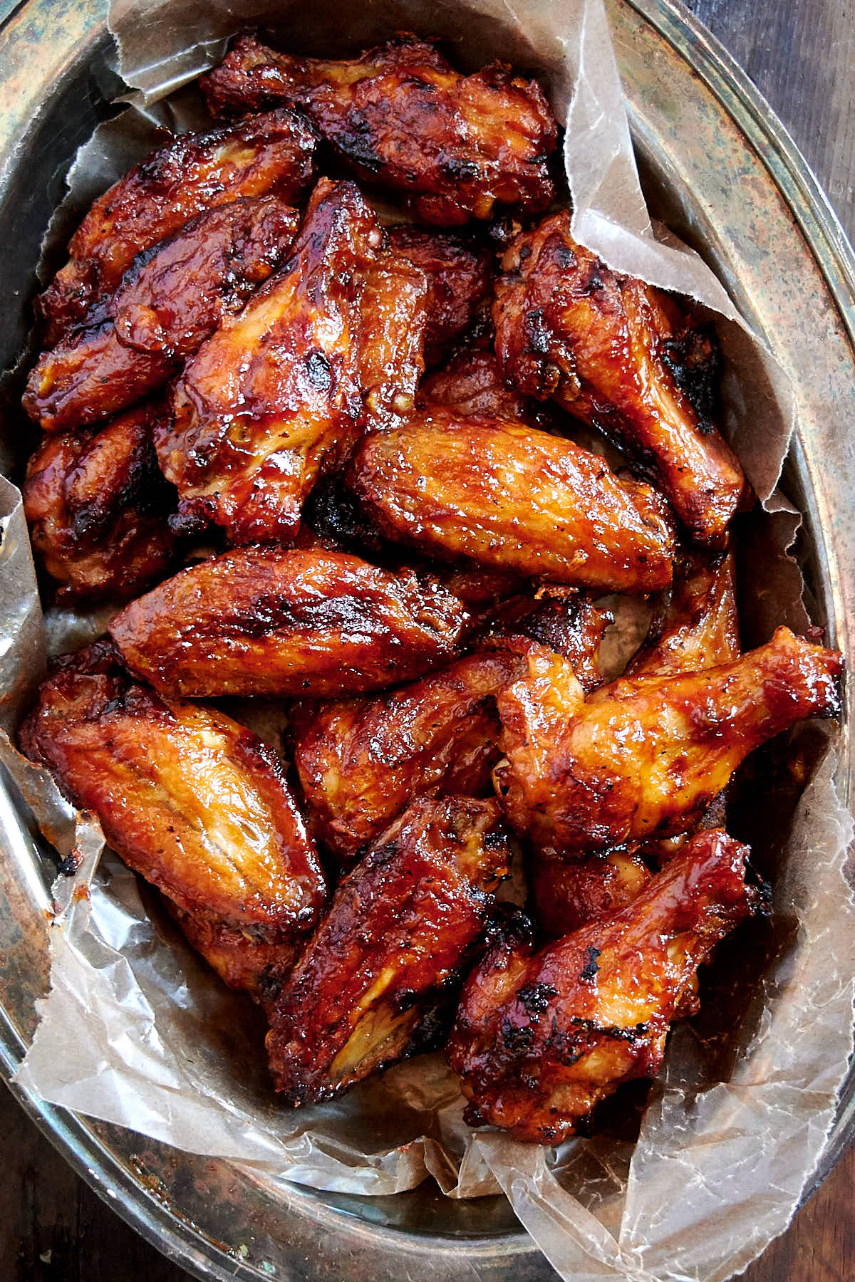 Baked BBQ Chicken Wings in a serving basket lined with wax paper.