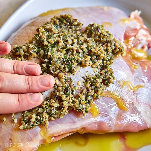 Roasted turkey breast - spreading herbs and garlic on top of turkey breast. | ifoodblogger.com