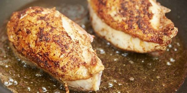 Chicken breast frying in oil.