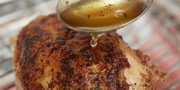 Drizzling hot oil over chicken breasts.