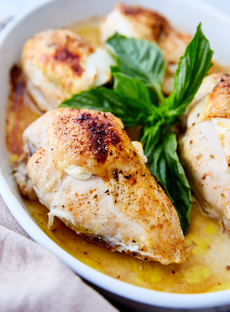 Crispy chicken breasts with basil in a baking pan.