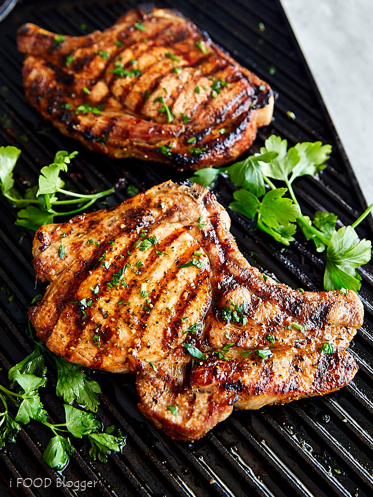 Close up of broiled pork chop on a cast iron griddle.