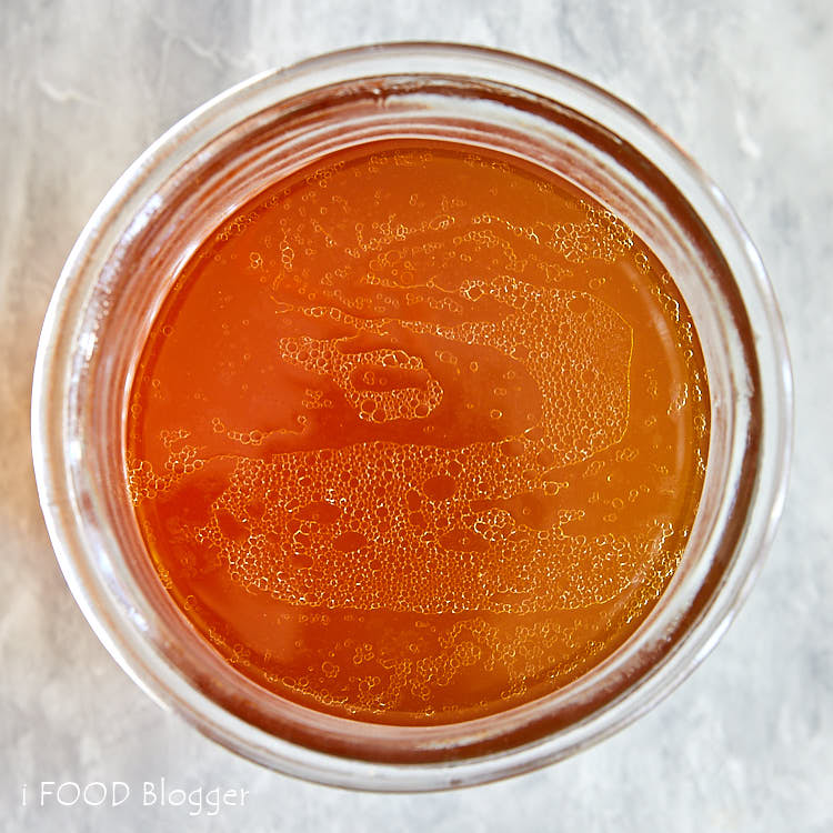 Top down view of bee consomme in a jar.