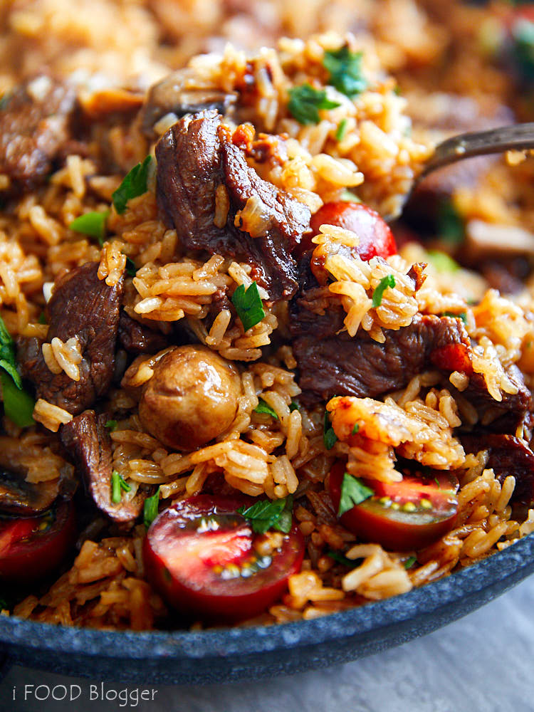 A close up of a spoonful of beef fried rice.