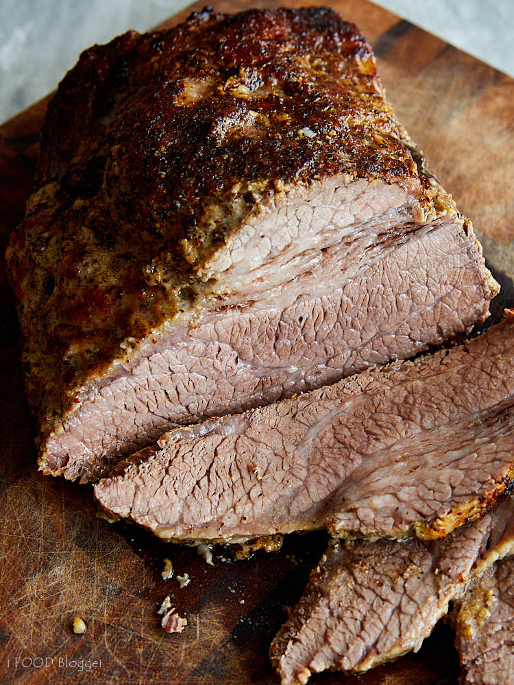 Juicy, well-browned oven-baked brisket sliced on a cutting board.