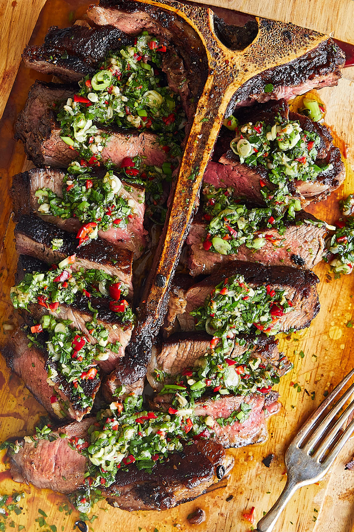 Sliced Porterhouse Steak with chimichurri on top.