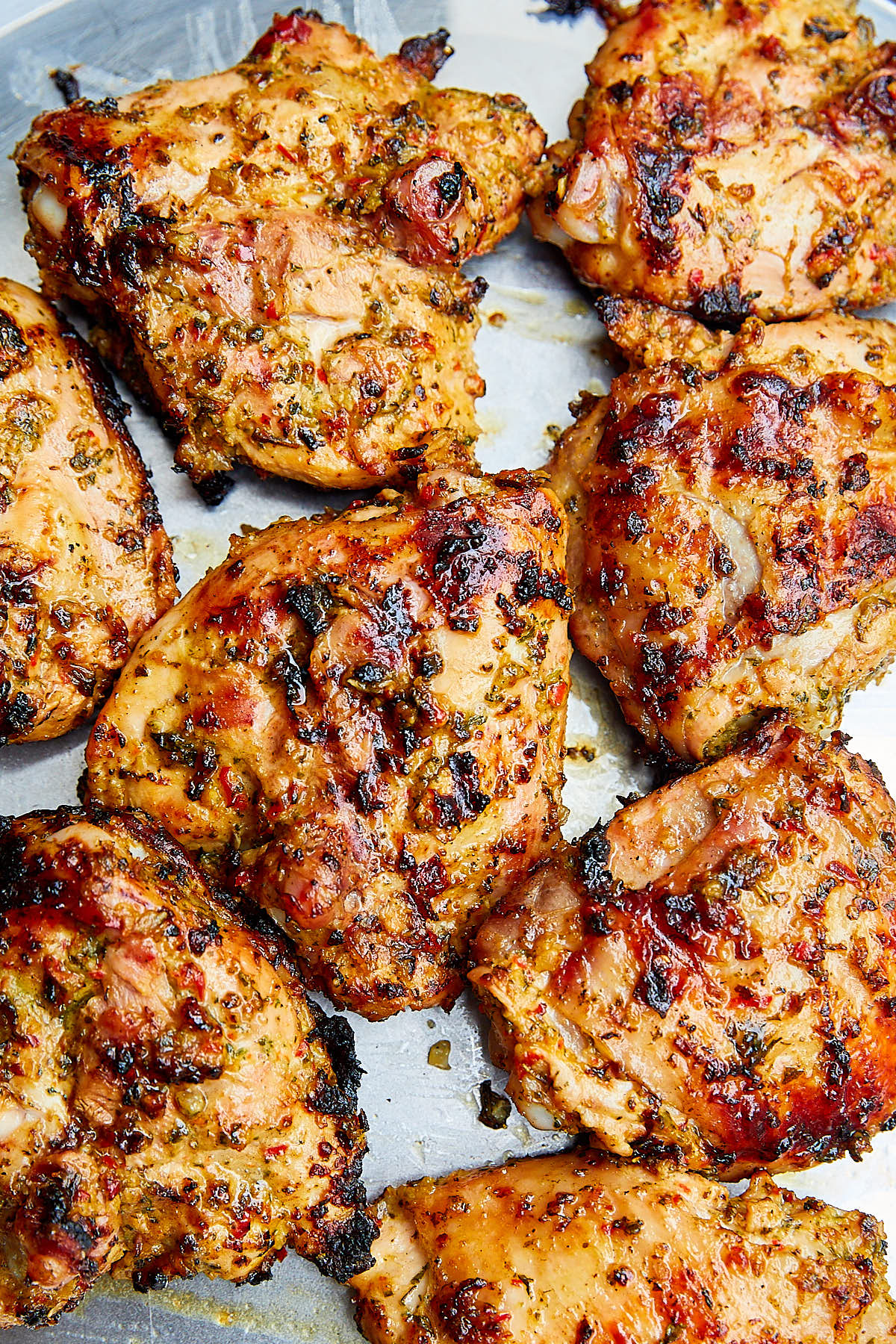 Grilled skin on chicken thighs on a serving platter.