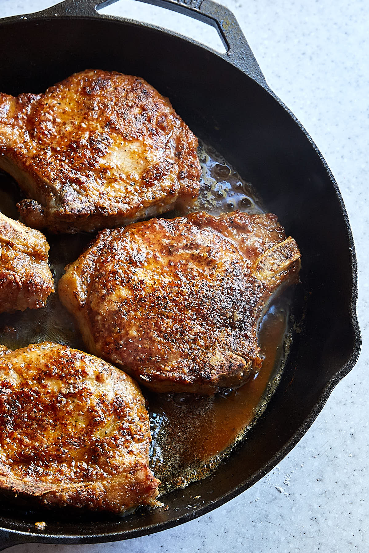 Classic Southern Fried Pork Chops in a cast iron pan.