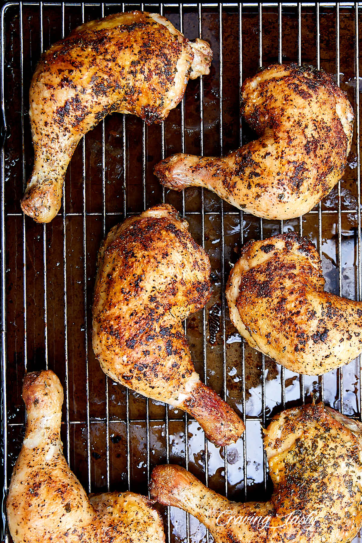 A top down view of six golden brown, crispy baked chicken quarters.