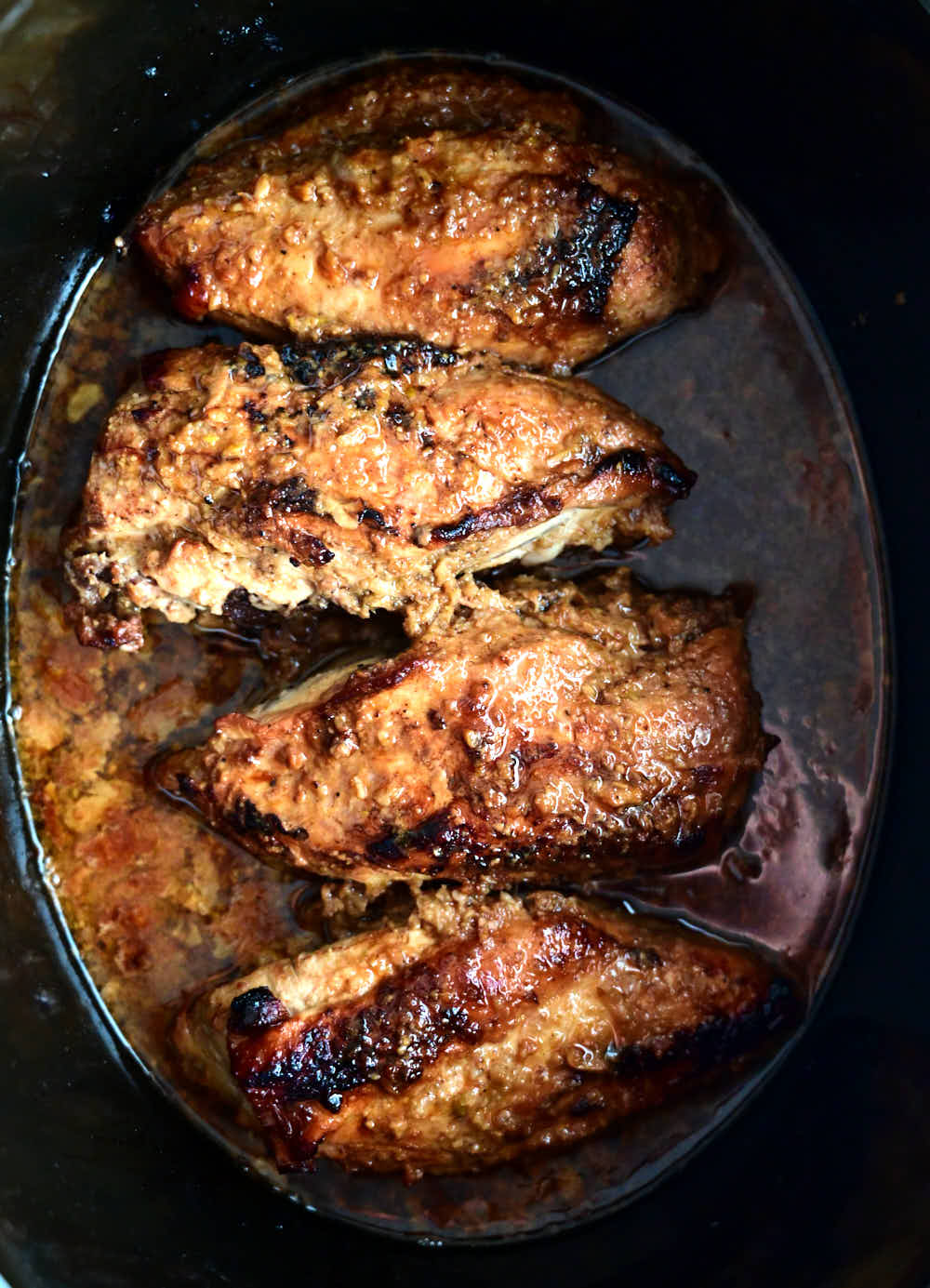 Gorgeous dark golden brown, moist chicken breasts inside a Crock Pot.