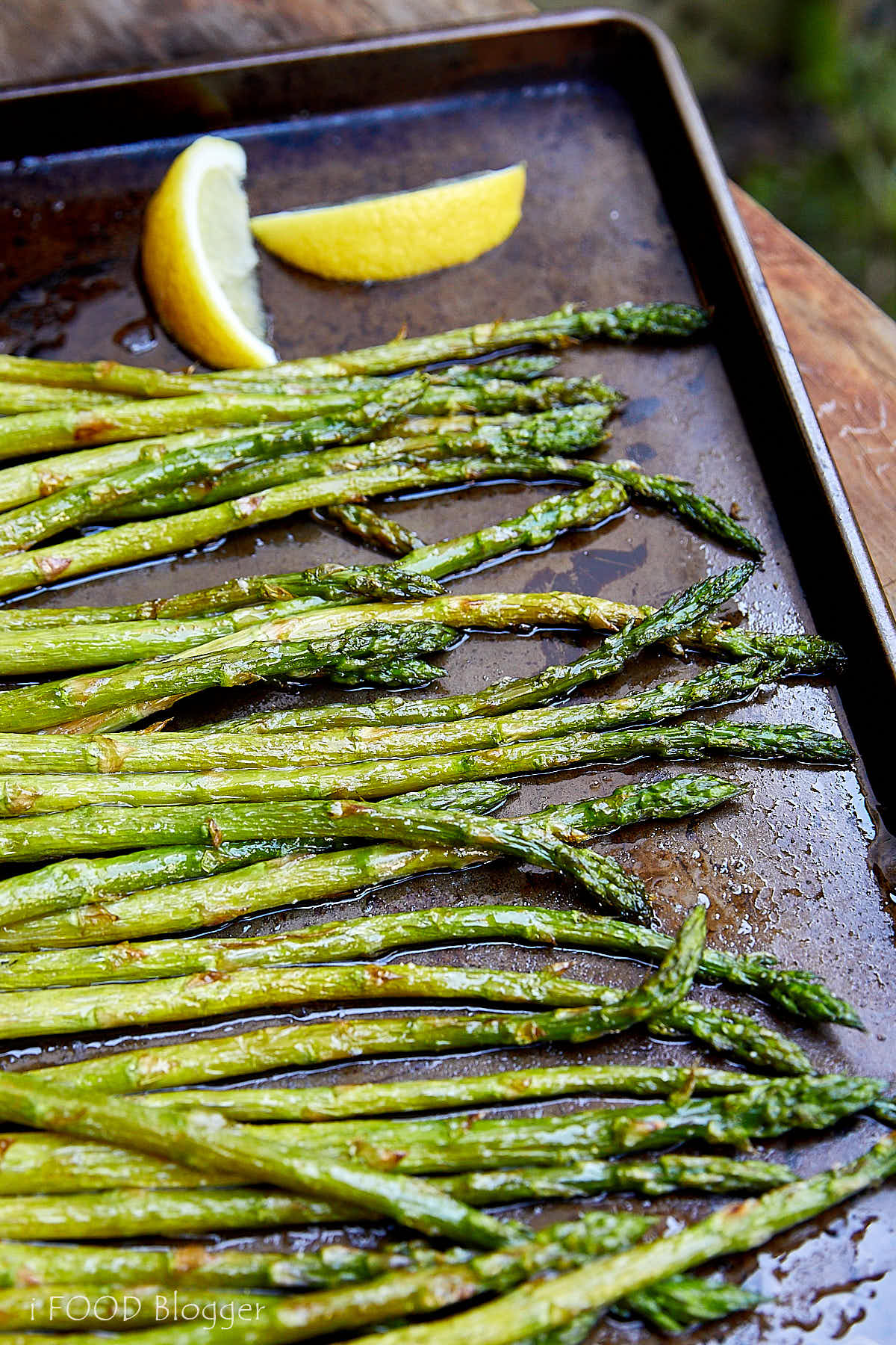 Broiled asparagus with lemon on a baking sheet.