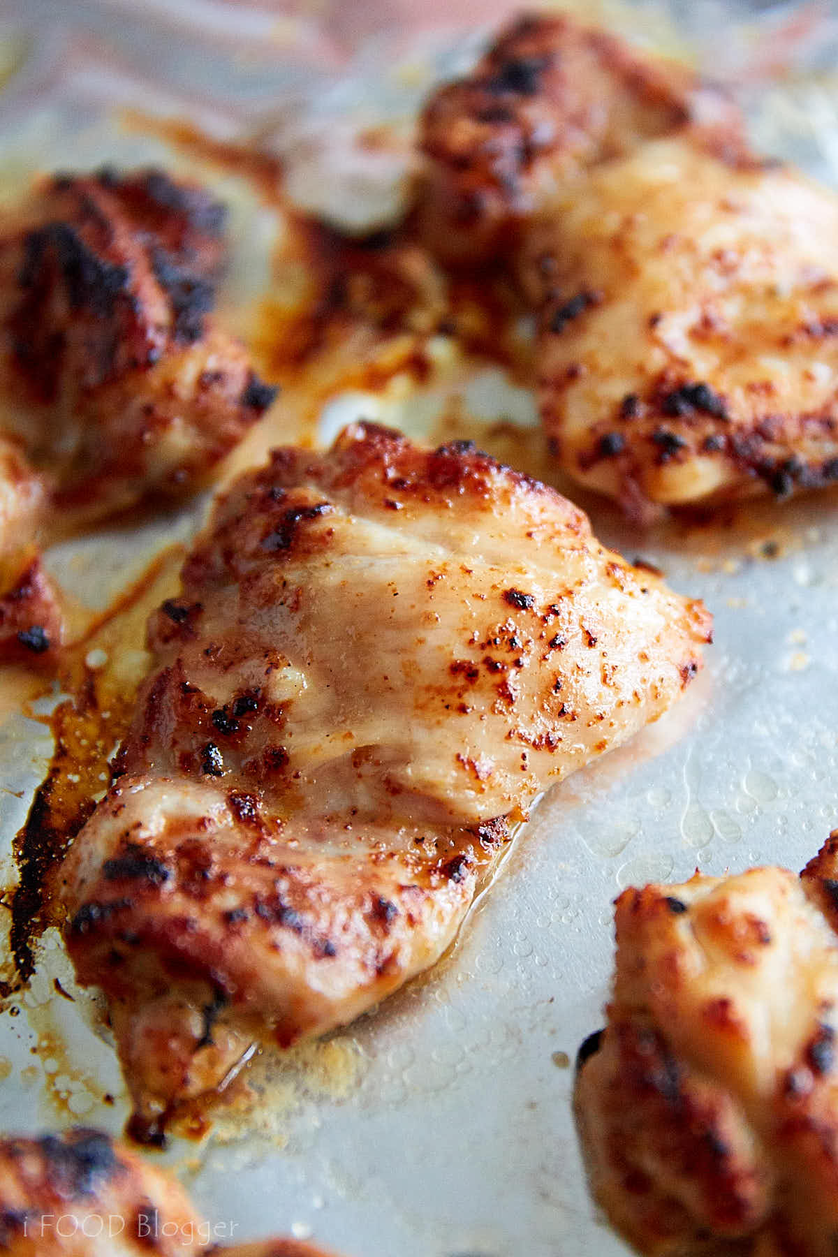 Close up view of a juicy, crispy broiled chicken thigh.