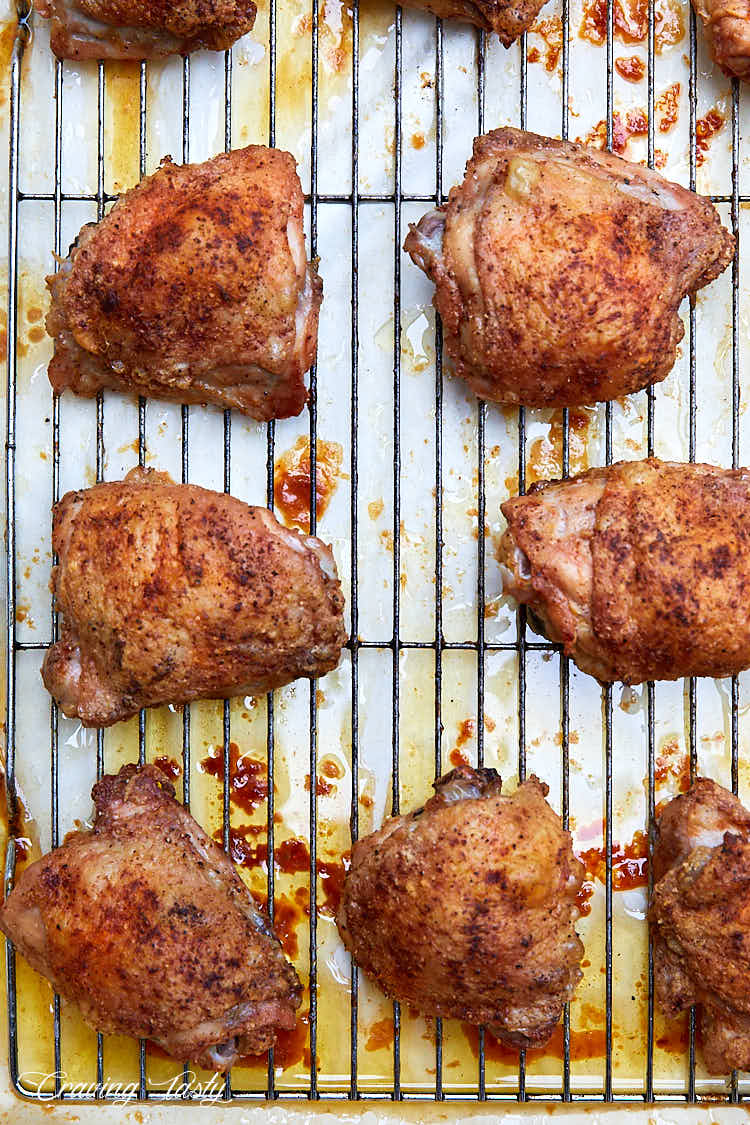 Crispy chicken thighs, well-browned, on a cooling rack.