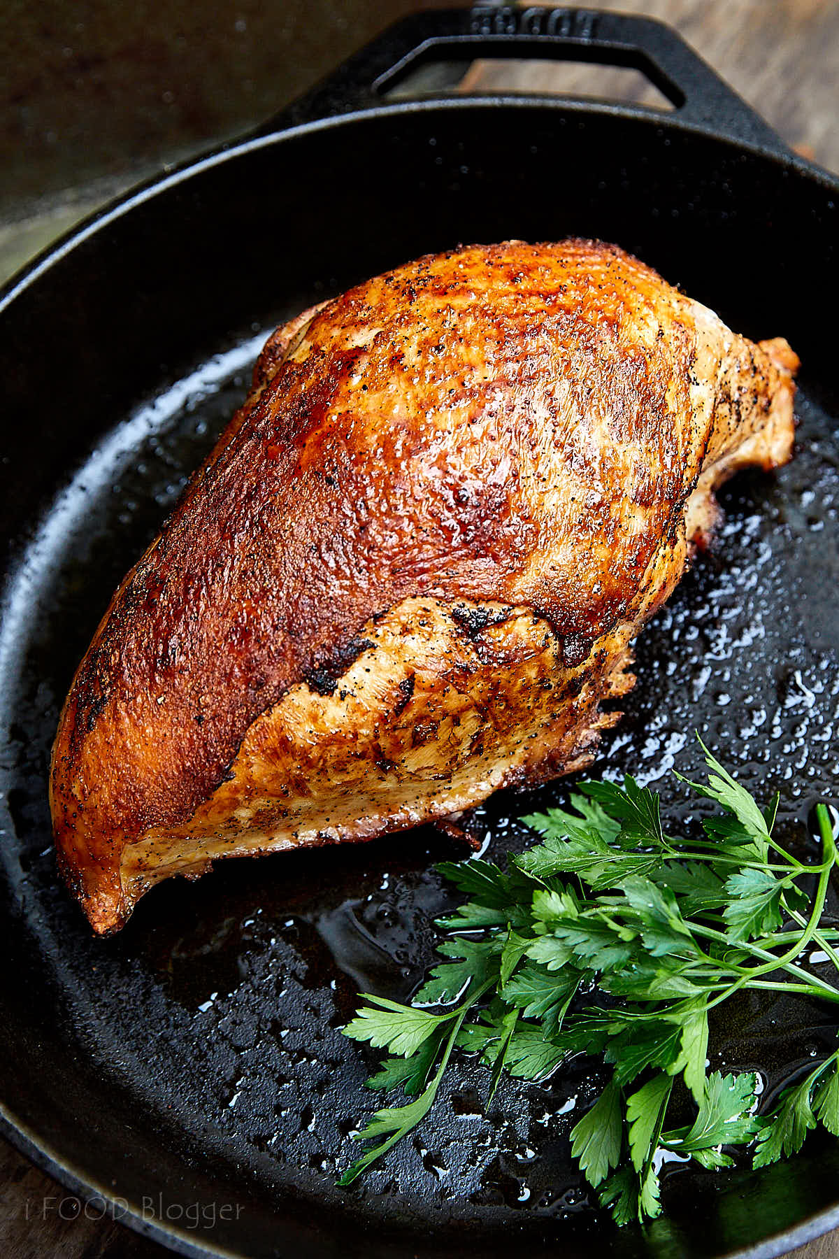 Well-browned turkey breast on a cast iron pan.