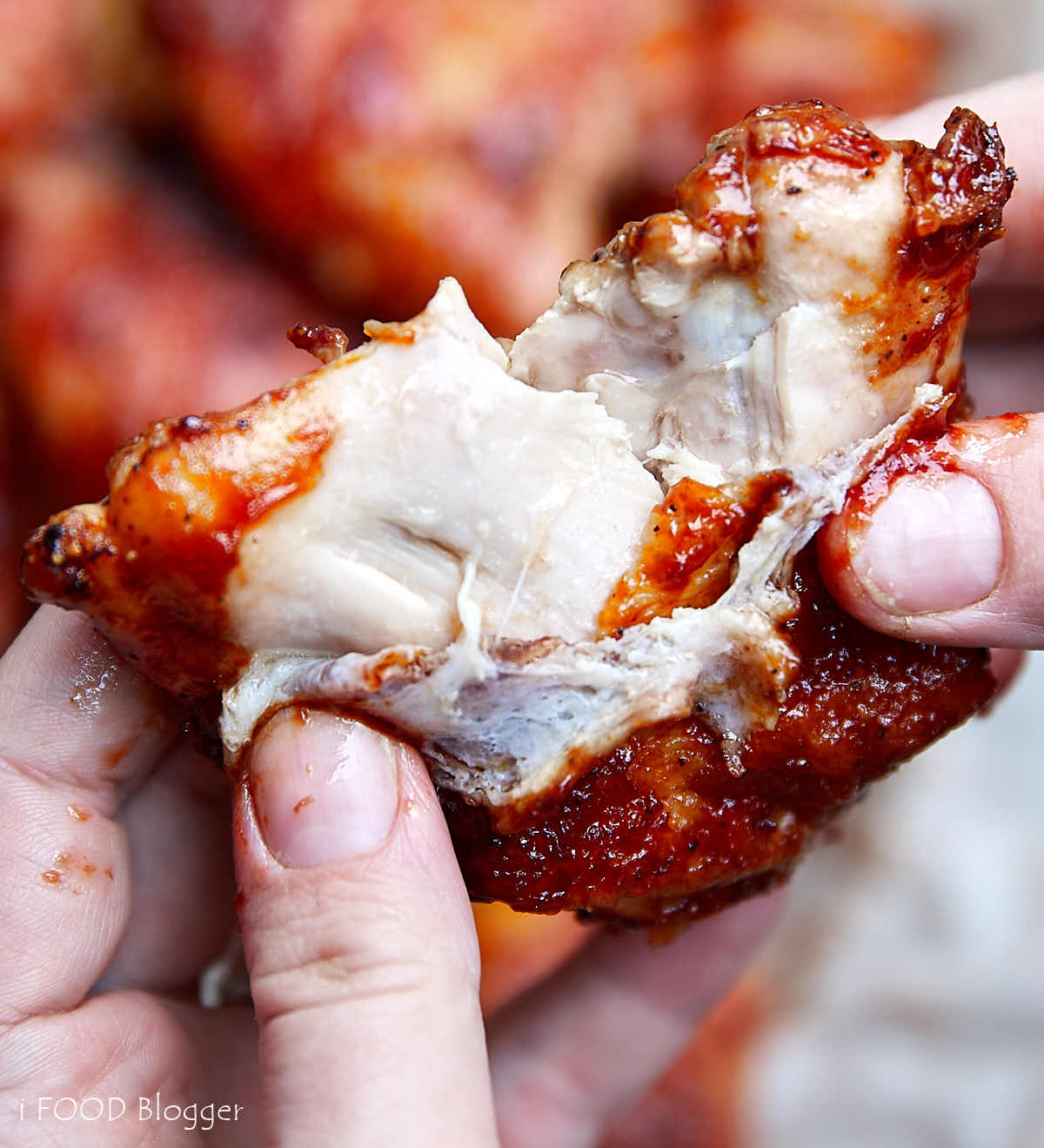 BBQ sauce glazed baked chicken thigh split in half, showing juicy, moist meat.