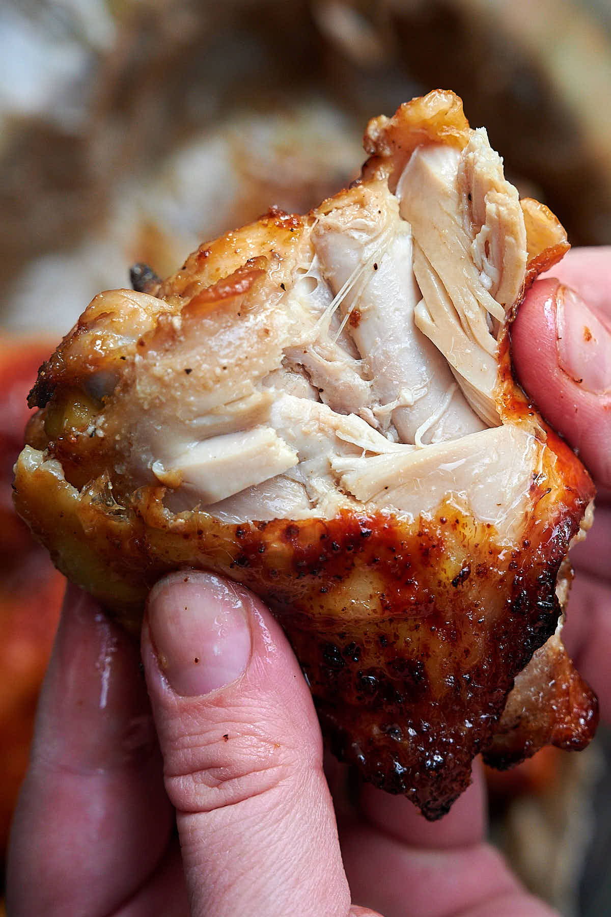 A close up of air fried chicken thighs split open, showing juicy, moist meat.