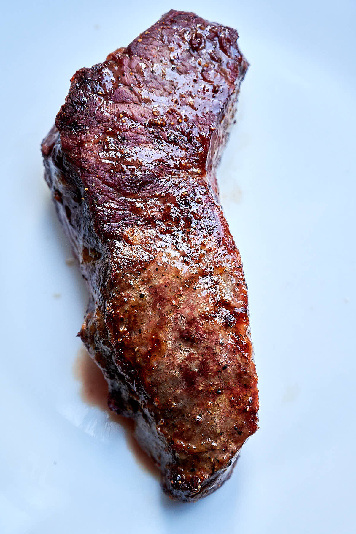 Air fried steak with one half buttered and the other un-buttered.