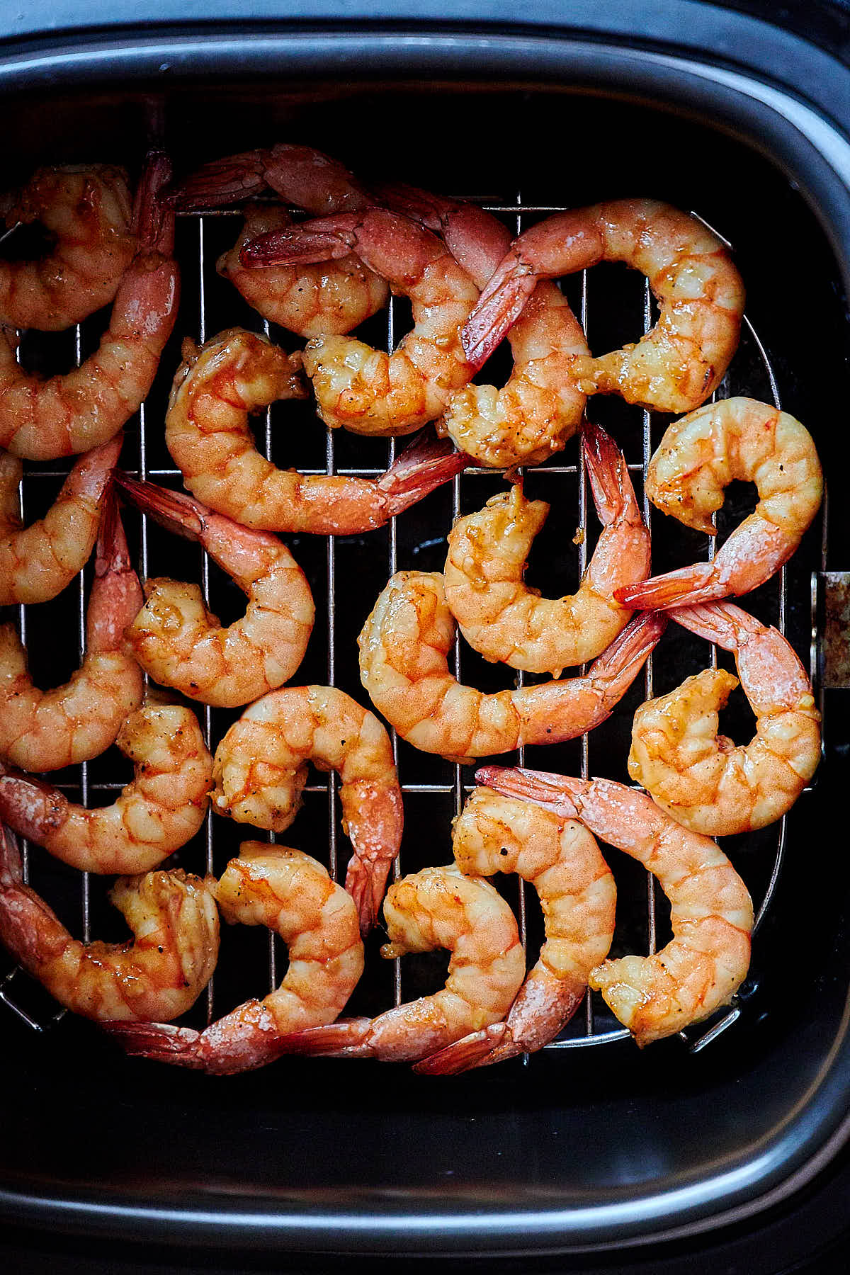 Shrimp cooking inside an air fryer.