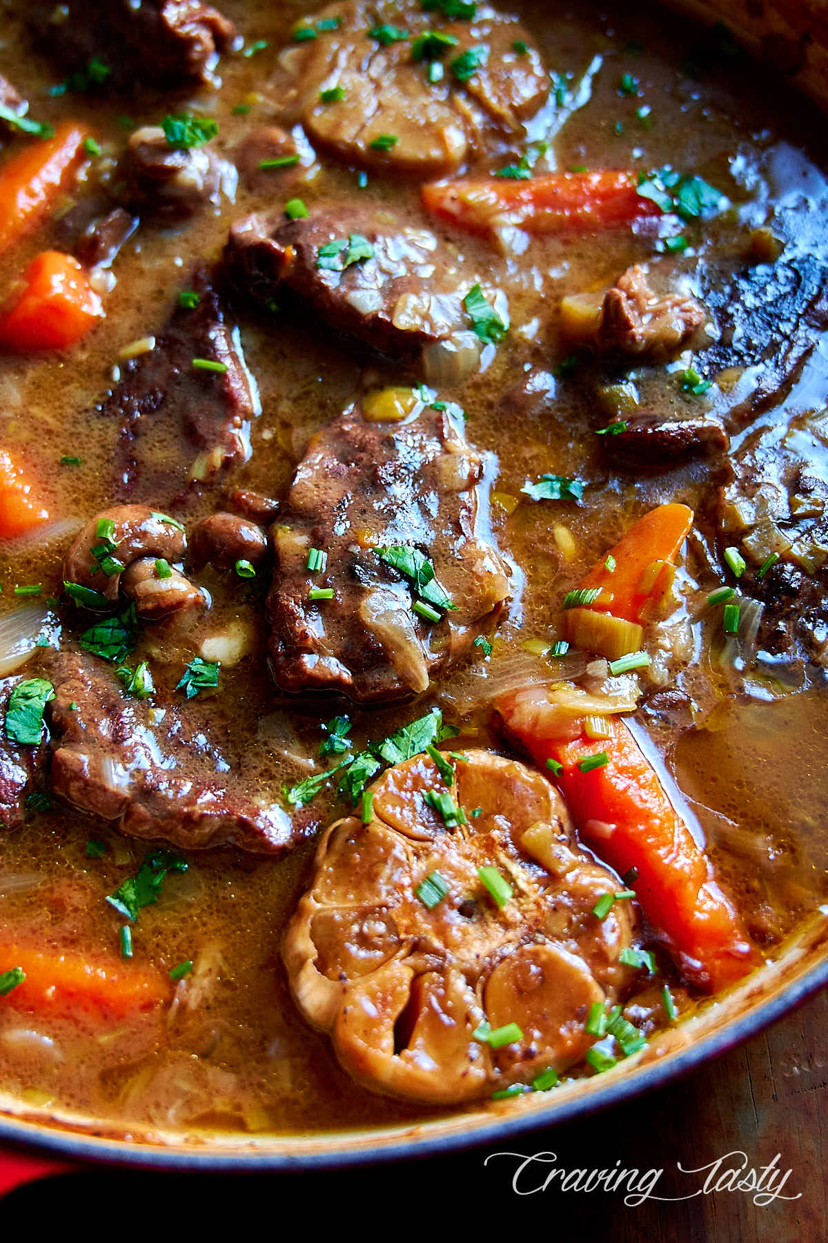 Close up of chunks of braised beef in a pan.