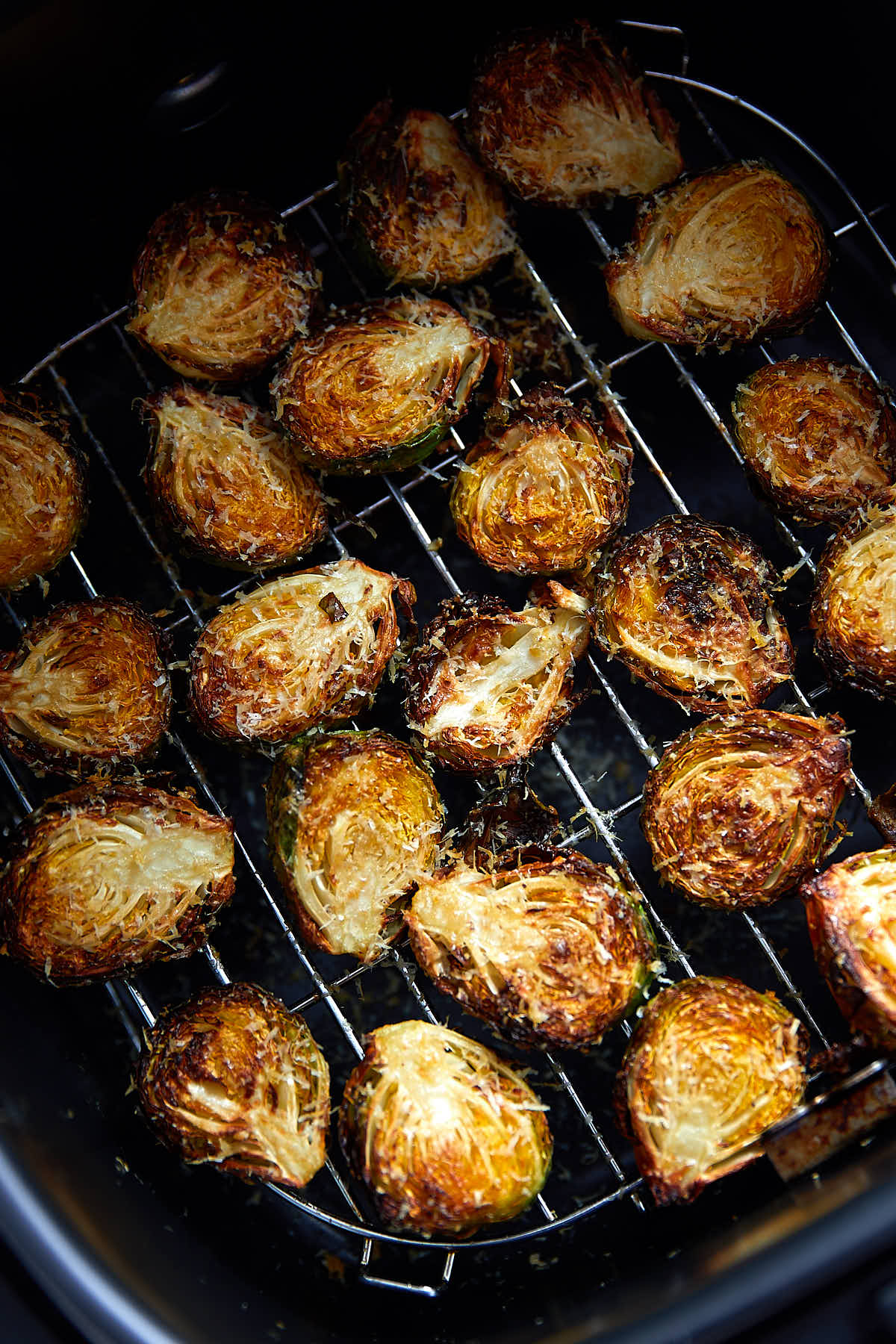 Crispy air fried Brussels sprouts inside an air fryer.