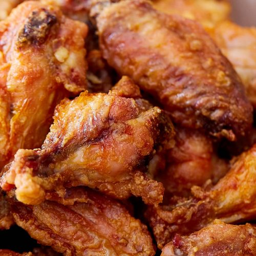Close up of extra crispy chicken wings in a serving basket.