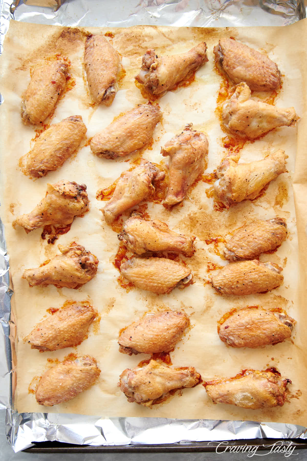 Baked crispy wings on baking sheet lined with parchment paper.
