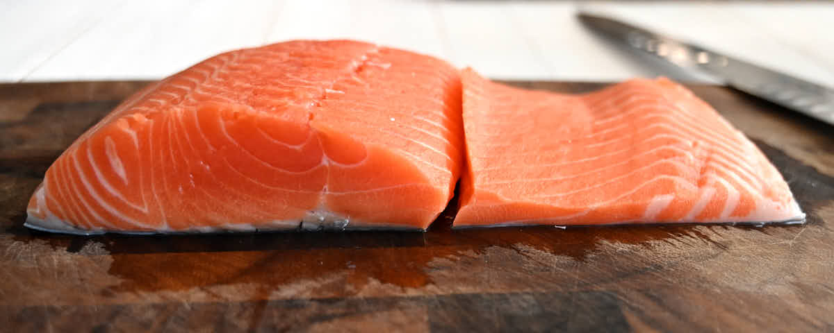 View of salmon filet with thick and thin parts split apart.