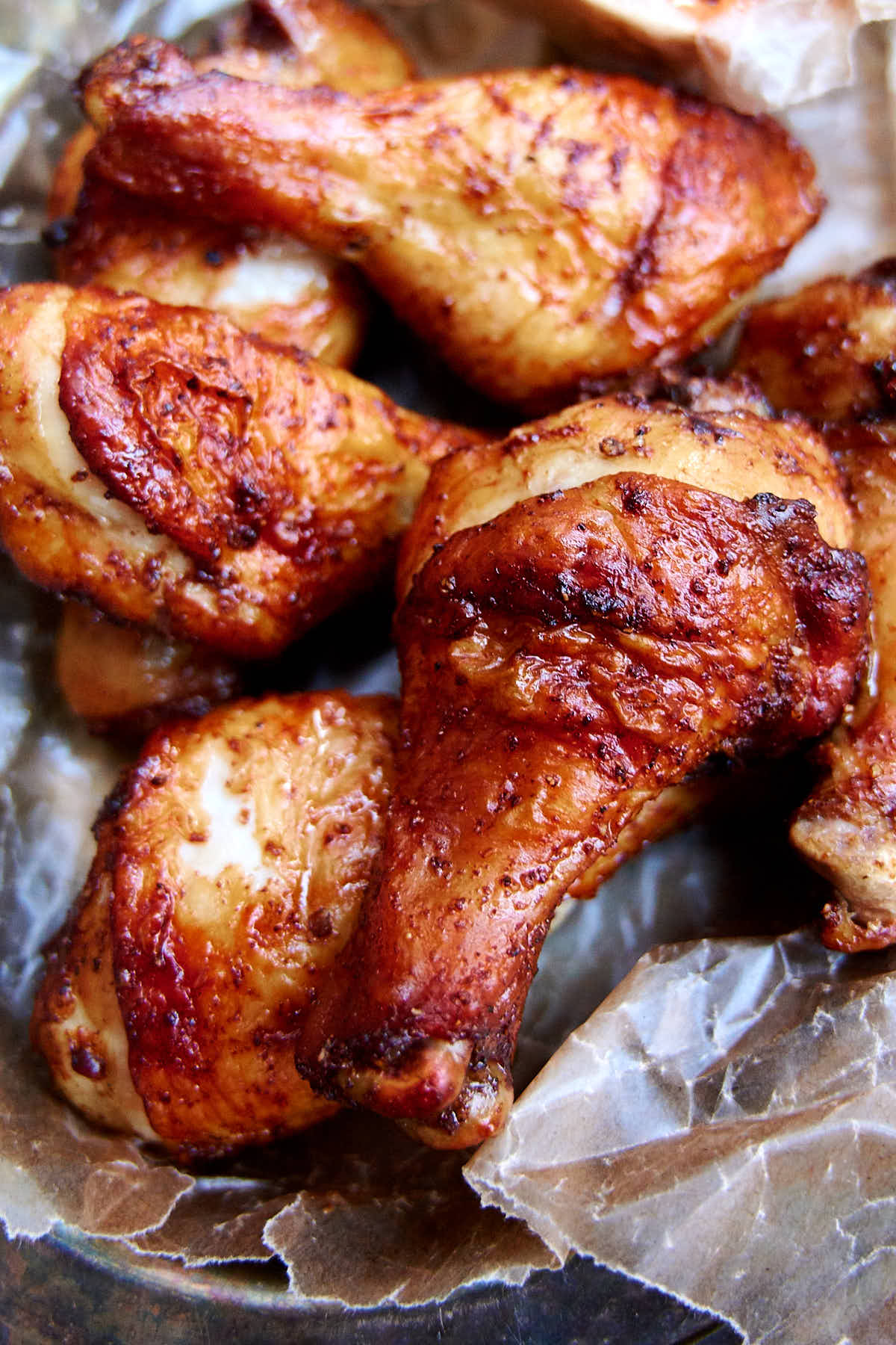 Air fried chicken legs in a basked lined with wax paper.