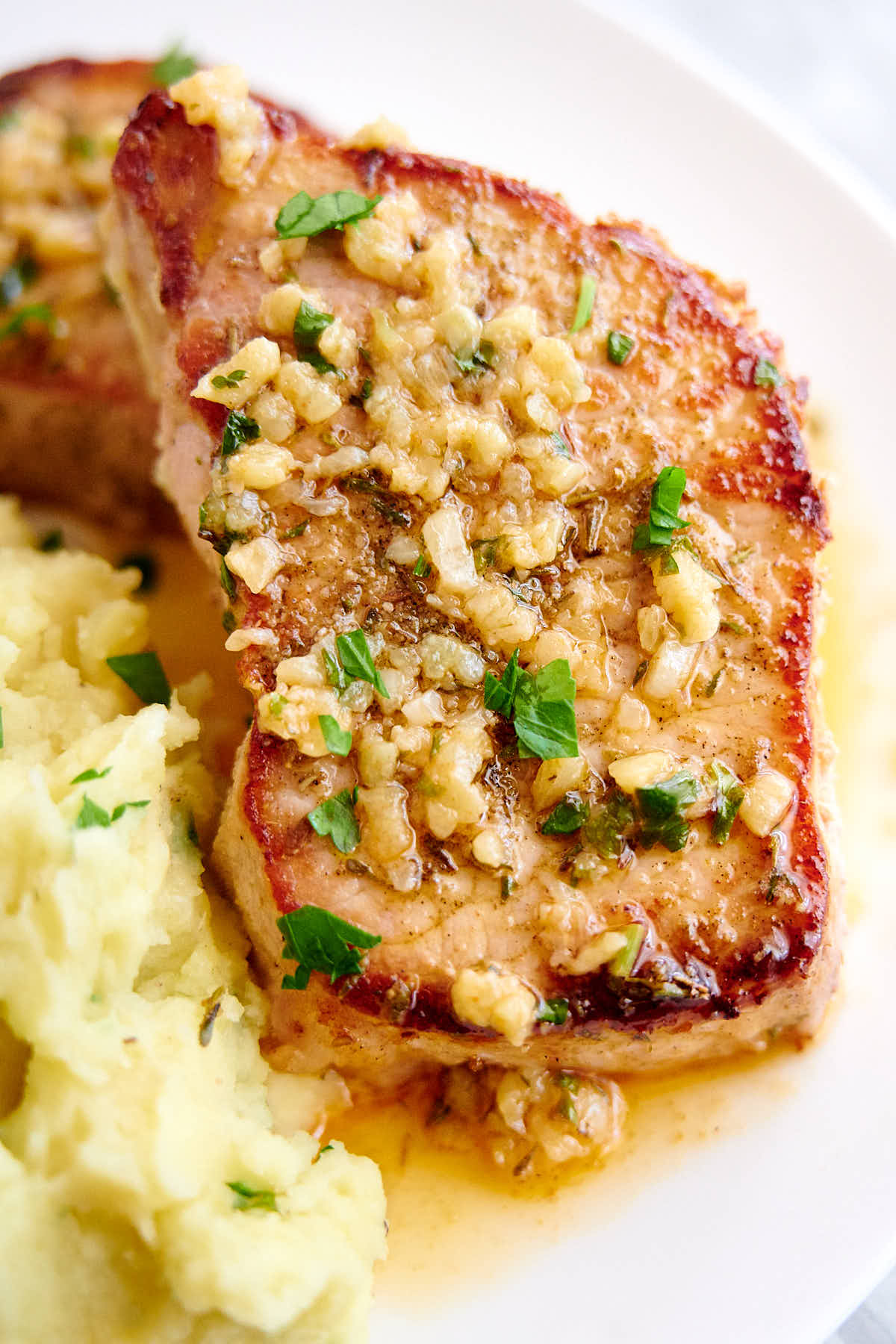 A delicious, juicy baked pork chop on a plate.