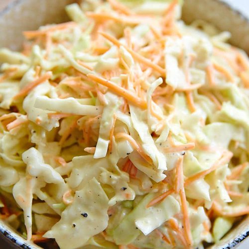 Top down close up view of a bowl filled with homemade coleslaw.