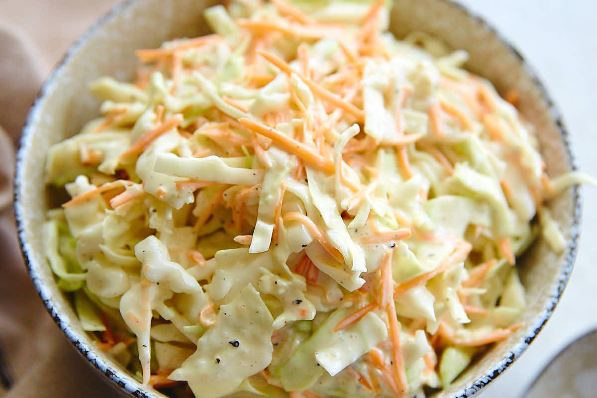 Top down close up view of a bowl filled with homemade coleslaw.