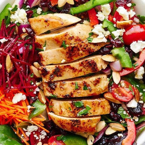 A close up of a bowl of grilled chicken salad.