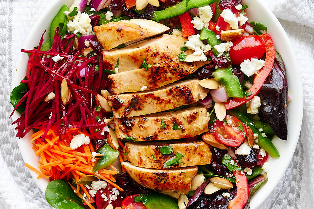 A close up of a bowl of grilled chicken salad.
