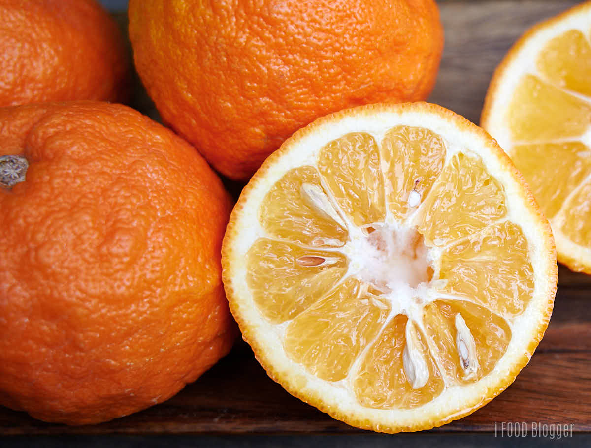 Seville Oranges (also called Sour Oranges, naranjas agrias) on a wooden plate. 