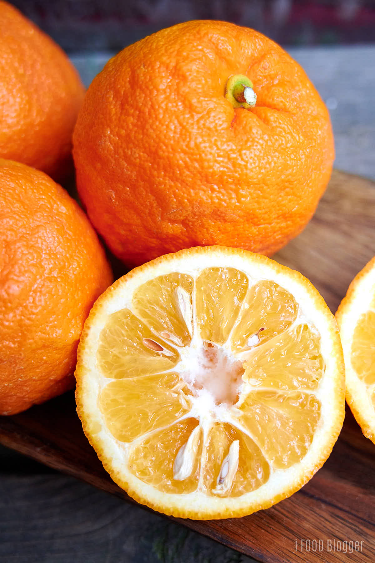 Seville Oranges (also called Sour Oranges, naranjas agrias) on a wooden plate. 