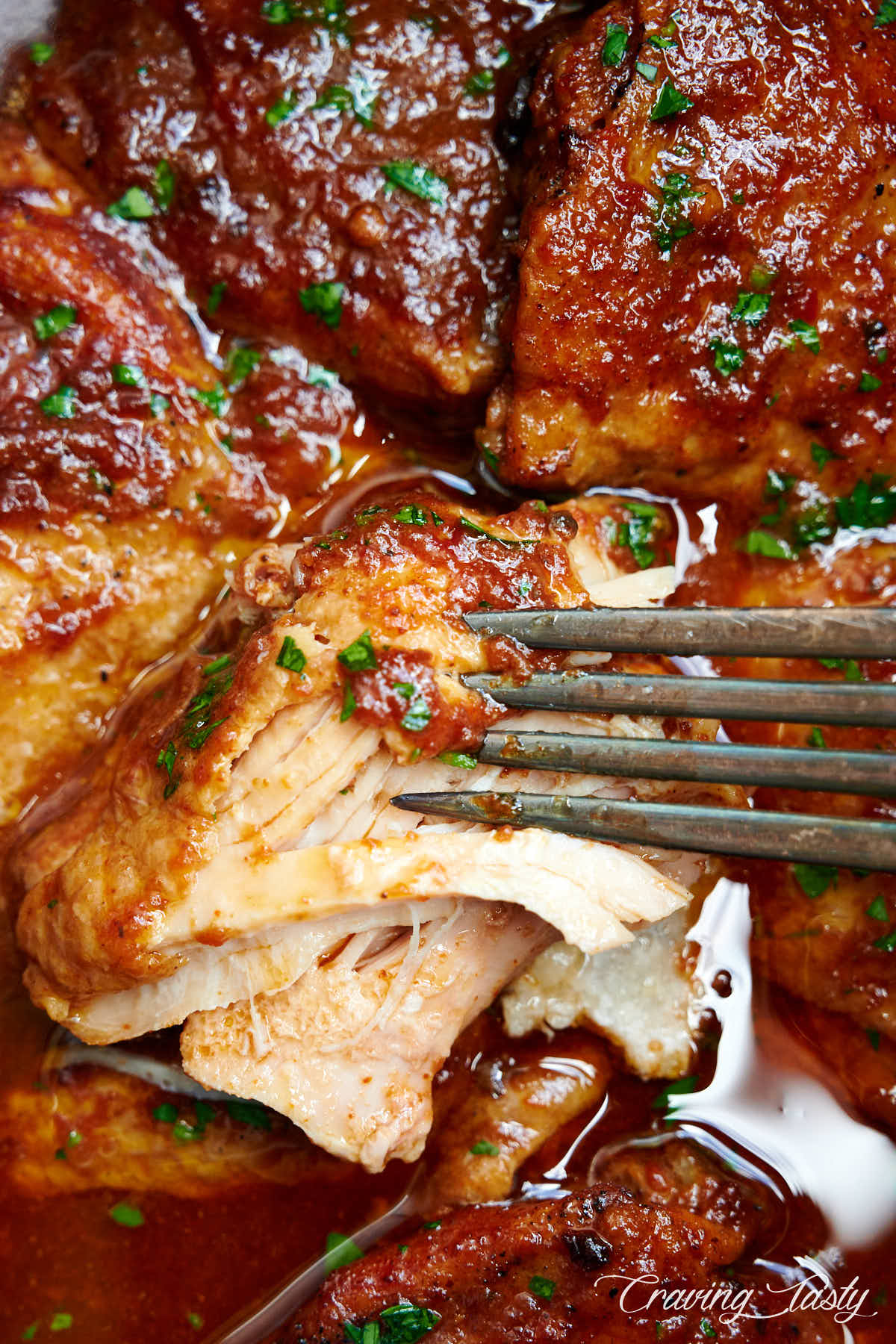 Close up of BBQ chicken inside slow cooker shredded with a fork.