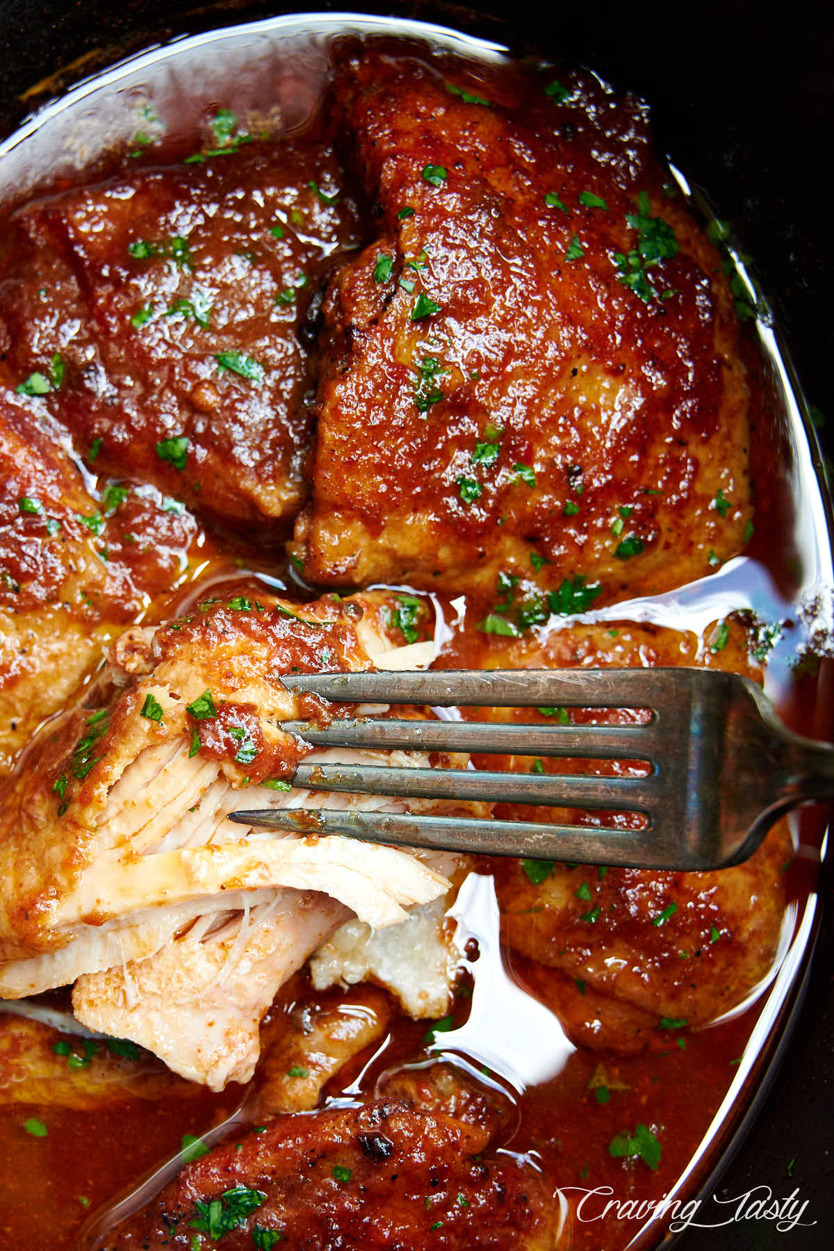 BBQ chicken in a slow cooker, pulled by a fork.