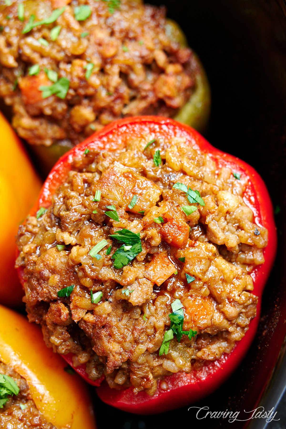 Red bell pepper stuffed with minced meat and garnished with chopped parsley.