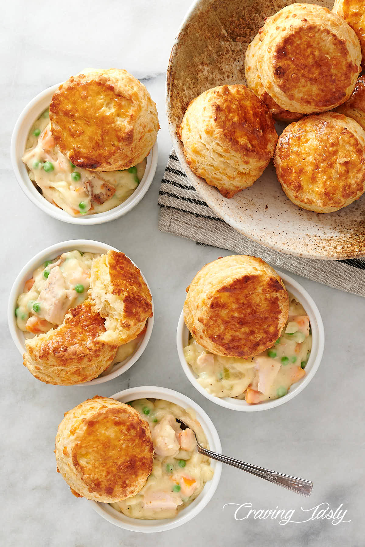 Ramekins filled with creamy chicken, topped with golden brown biscuits.