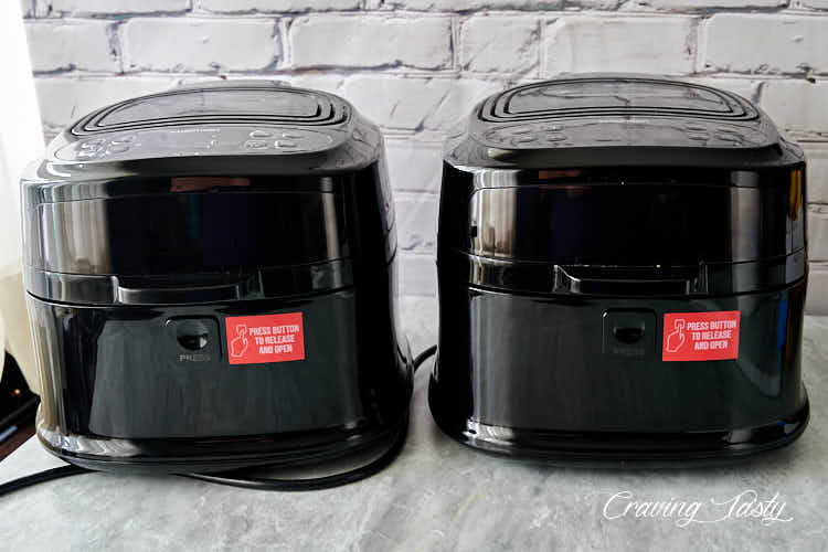 Two air fryers on a table.