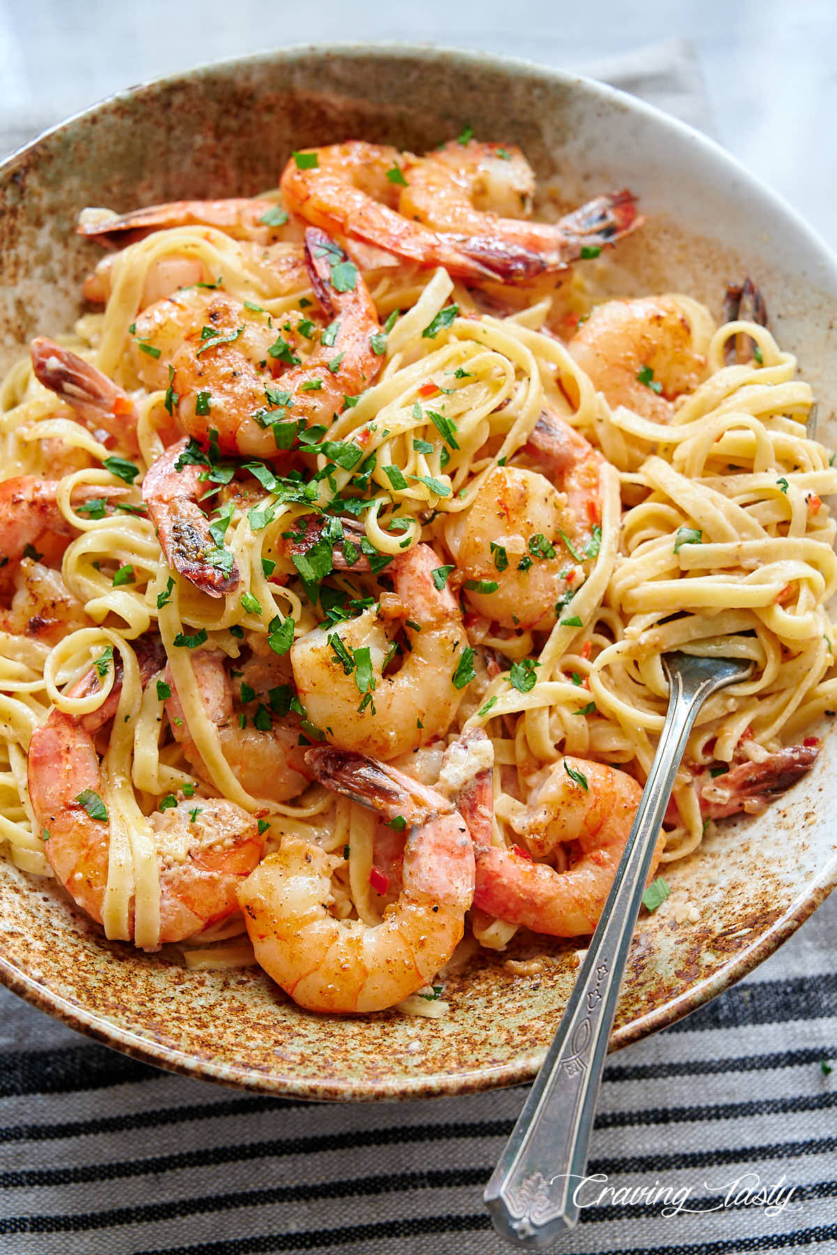 Garlic butter shrimp and pasta in a bowl garnished with parsley.