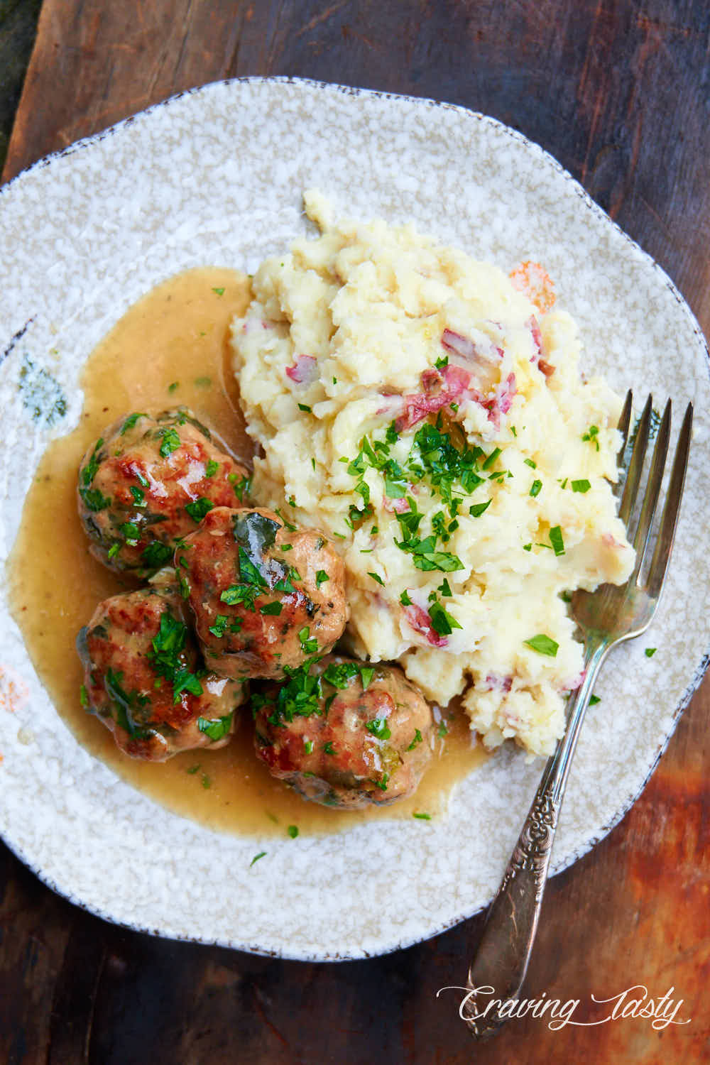 Turkey meatballs on a plate with mashed potatoes and gravy.